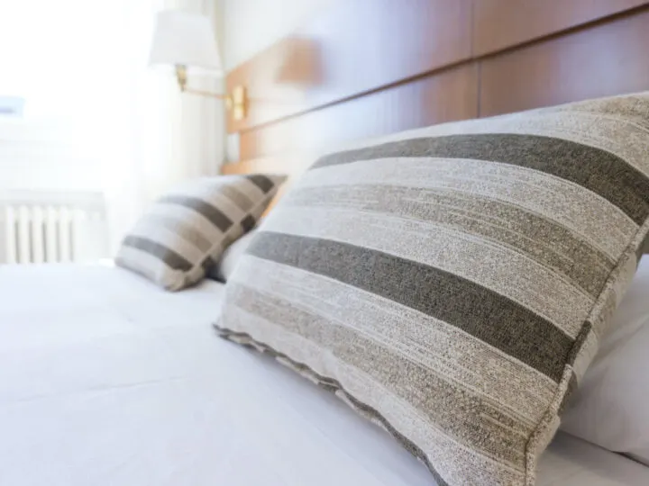 Striped pillows lying on a bed with white spread.
